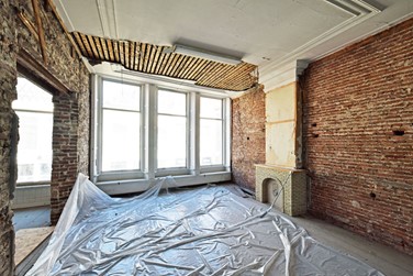 <p>Voorkamer op de verdieping van Oudestraat 100, met plafondafwerking, vensterbanken en schouwboezem uit 1917. </p>
